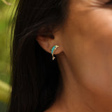 close up of woman wearing Dolphin Turquoise Earrings in Gold with Diamonds