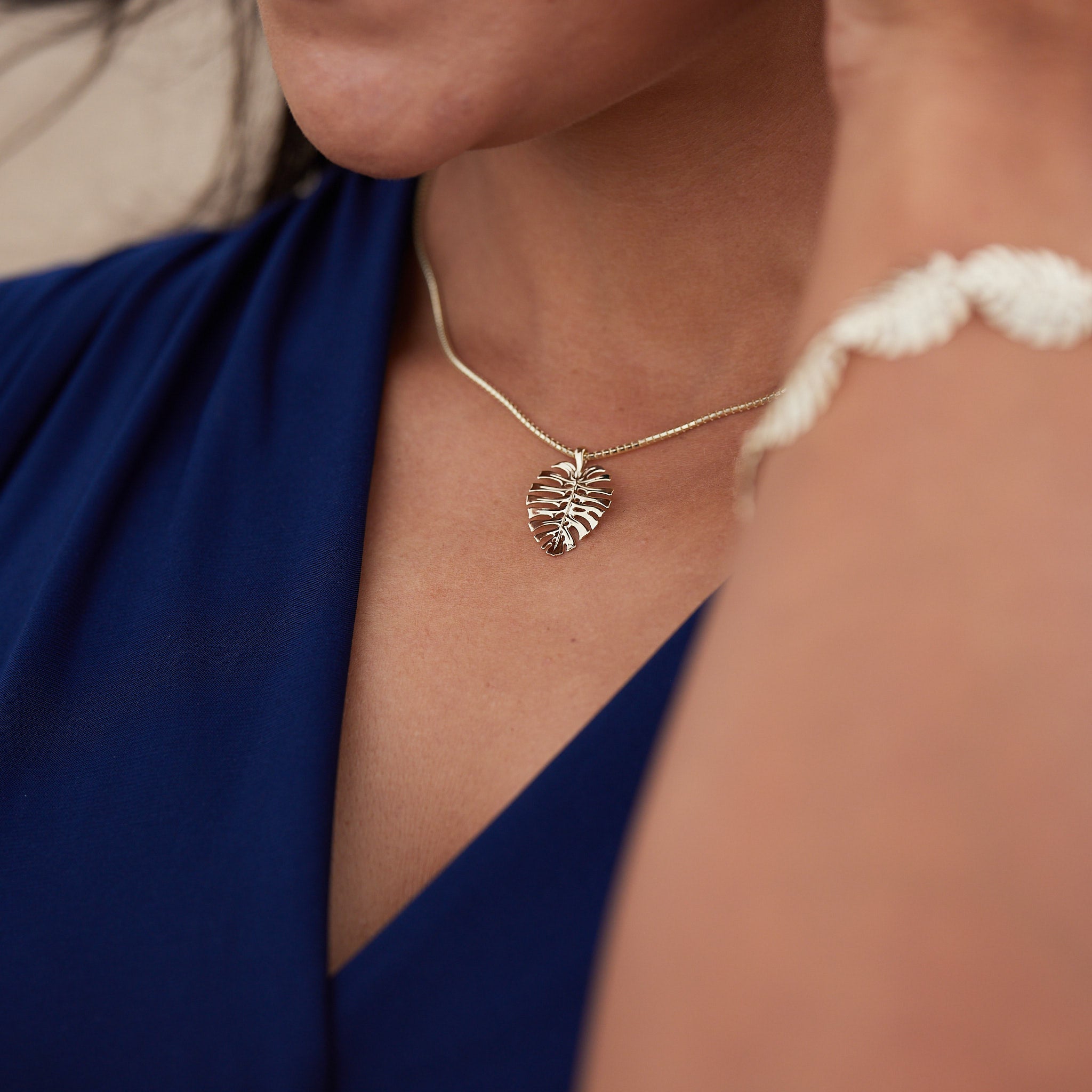 A woman wearing a Monstera Pendant in Gold - 20mm - Maui Divers Jewelry