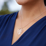 A woman's chest with a Monstera Pendant in Rose Gold - 30mm - Maui Divers Jewelry