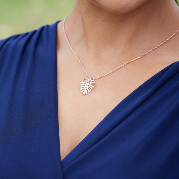 A woman wearing a Monstera Pendant in Rose Gold - 20mm - Maui Divers Jewelry