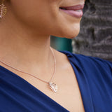 A woman wearing a Monstera Pendant in Rose Gold - 20mm - Maui Divers Jewelry