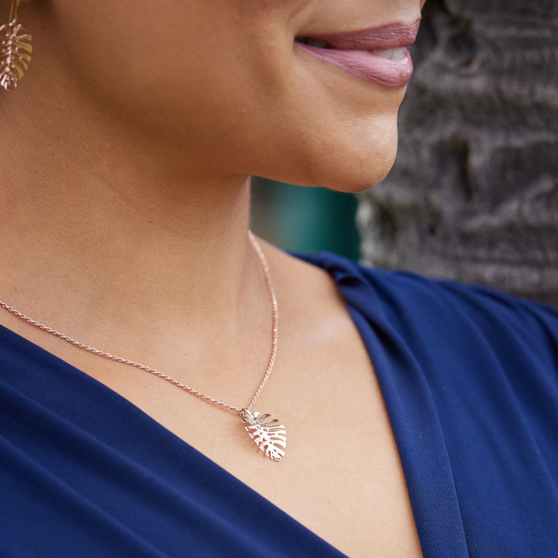 A woman wearing a Monstera Pendant in Rose Gold - 20mm - Maui Divers Jewelry