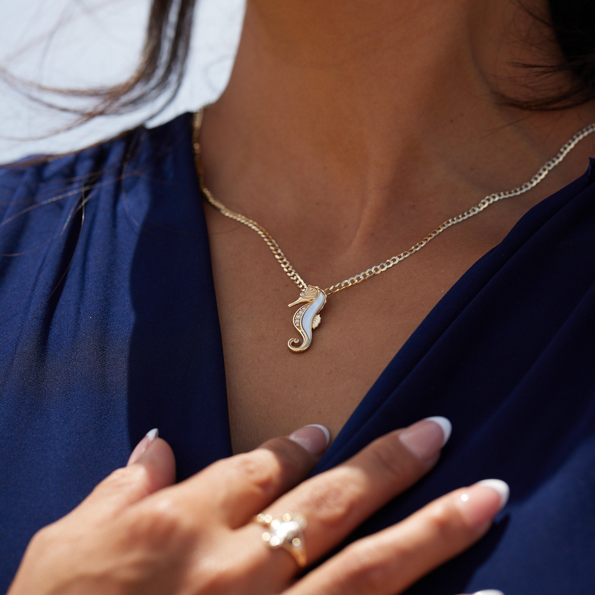 A woman's chest with a Sealife Seahorse Mother of Pearl Pendant in Gold with Diamonds - 27mm - Maui Divers Jewelry