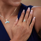 A woman wearing a Sealife Seahorse Turquoise Ring in Gold with Diamonds - 15mm and a whale necklace - Maui Divers Jewelry