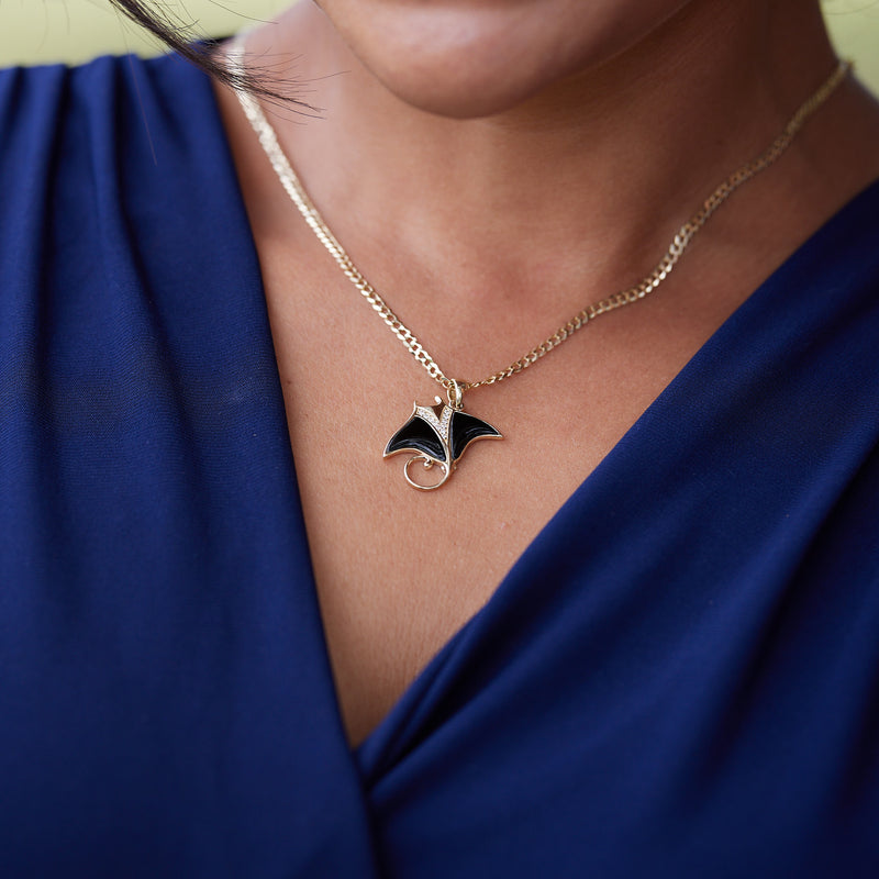 A woman wearing a Sealife Manta Ray Black Coral Pendant in Gold with Diamonds - Maui Divers Jewelry