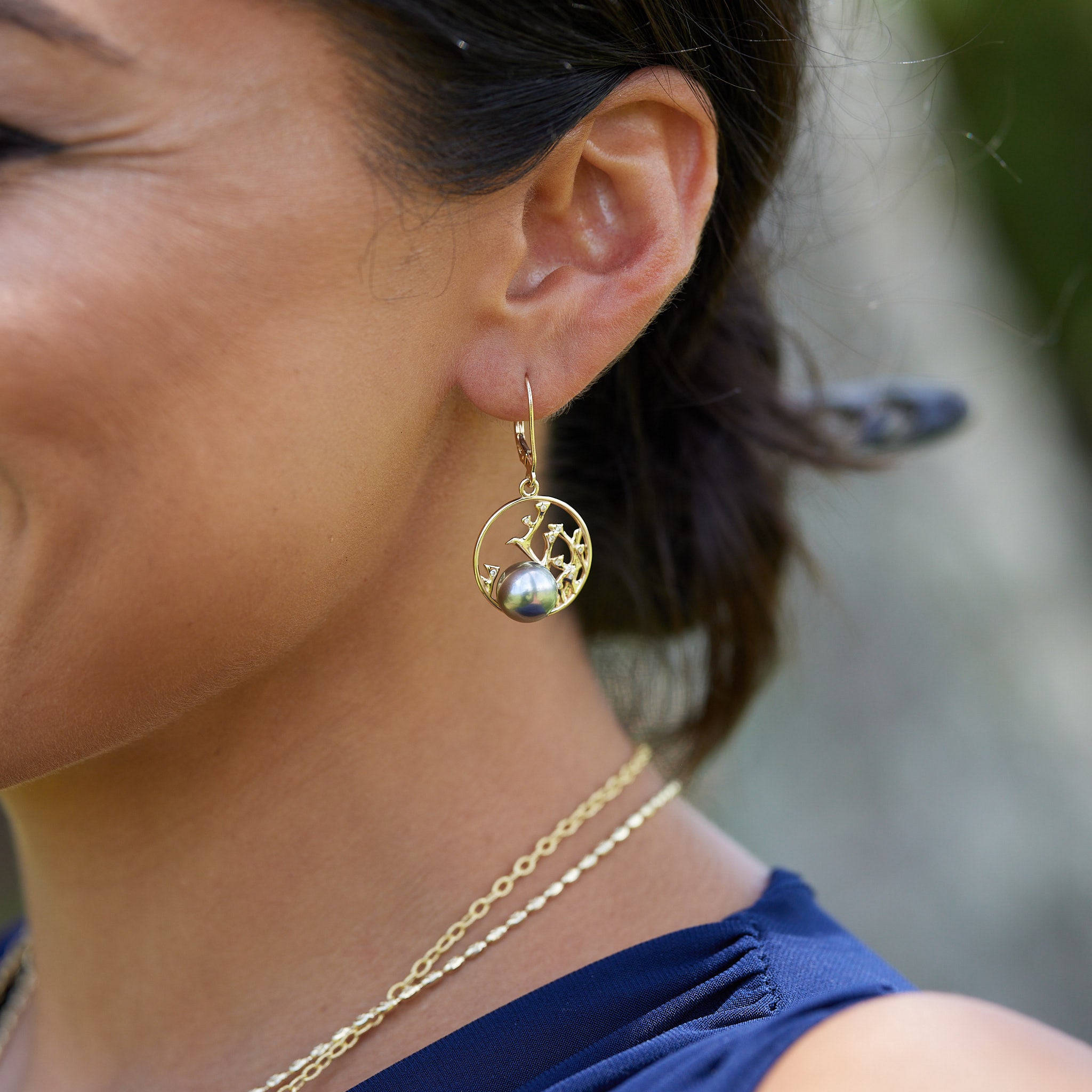 A woman's ear with Reefs Tahitian Black Pearl Earrings i Gold with Diamonds - 9-10mm - Maui Divers Jewelry