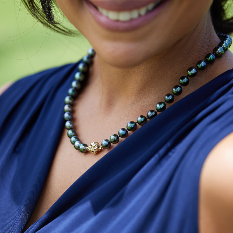 A womanʻs chest with a Tahitian Black Pearl Strand with Magnetic Gold Clasp - Maui Divers Jewelry