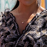 A woman wearing a Ohia Lehua Ruby Pendant in Two Tone Gold - 15 mm - Maui Divers Jewelry