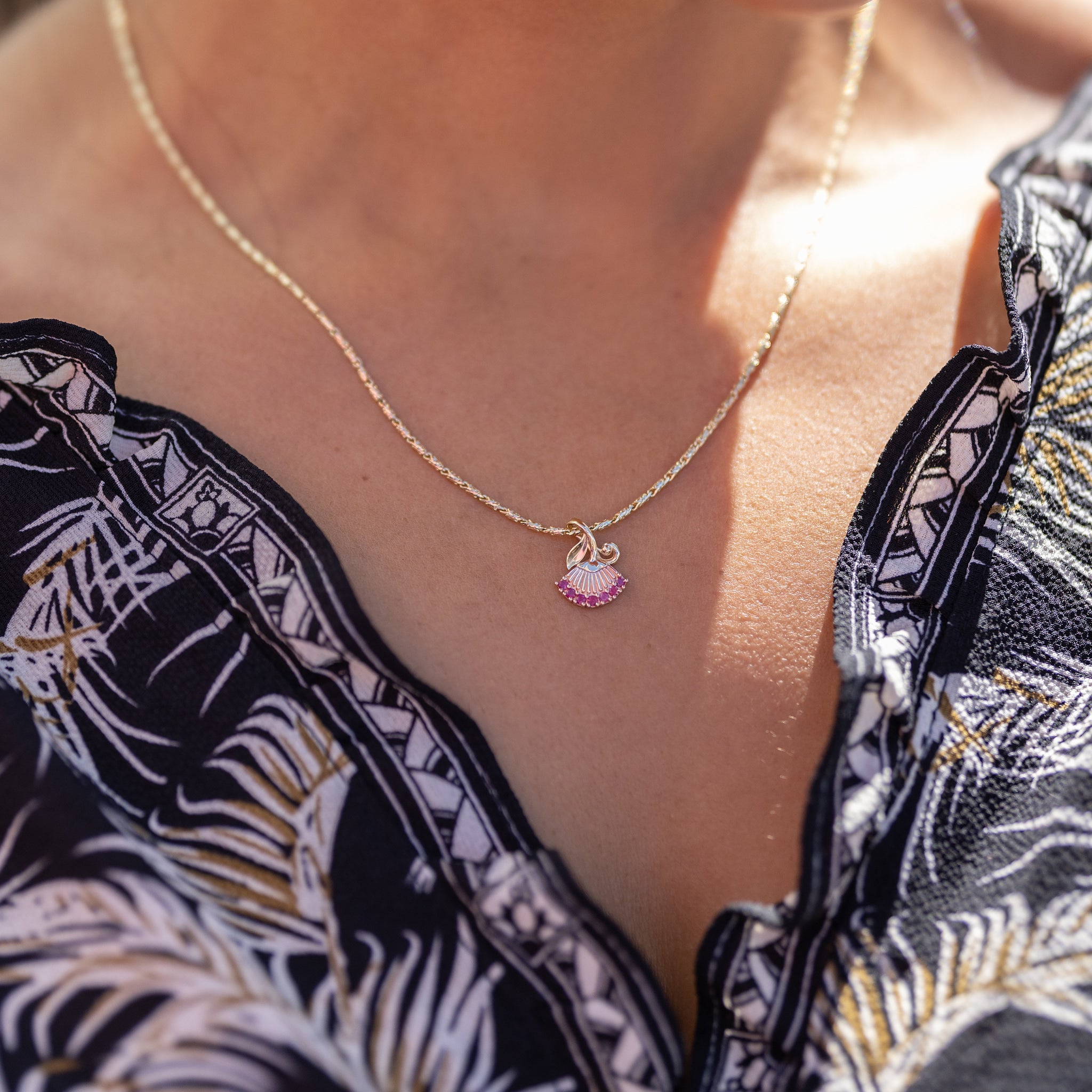 A woman wearing a Ohia Lehua Ruby Pendant in Two Tone Gold - 15 mm - Maui Divers Jewelry