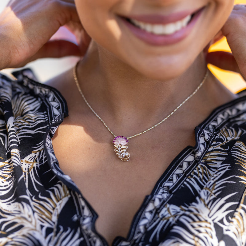 A woman wearing a Ohia Lehua Ruby Pendant in Two Tone Gold with Diamonds - 24mm necklace from Maui Divers Jewelry