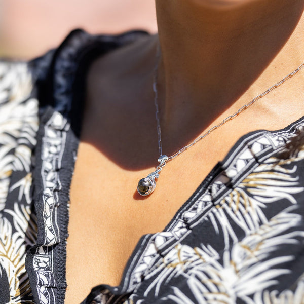 A woman's chest with a Living Heirloom Tahitian Black Pearl Pendant in White Gold with Diamonds - 9-10mm - Maui Divers Jewelry