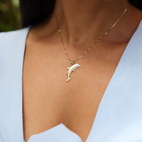 close up of woman wearing Dolphin Mother of Pearl Pendant in Gold with Diamonds