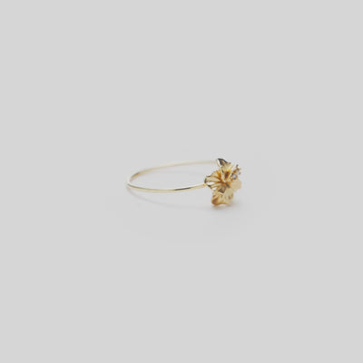 8mm Hawaiian Gardens Hibiscus Ring in 14k Yellow Gold with Diamonds on a white turntable
