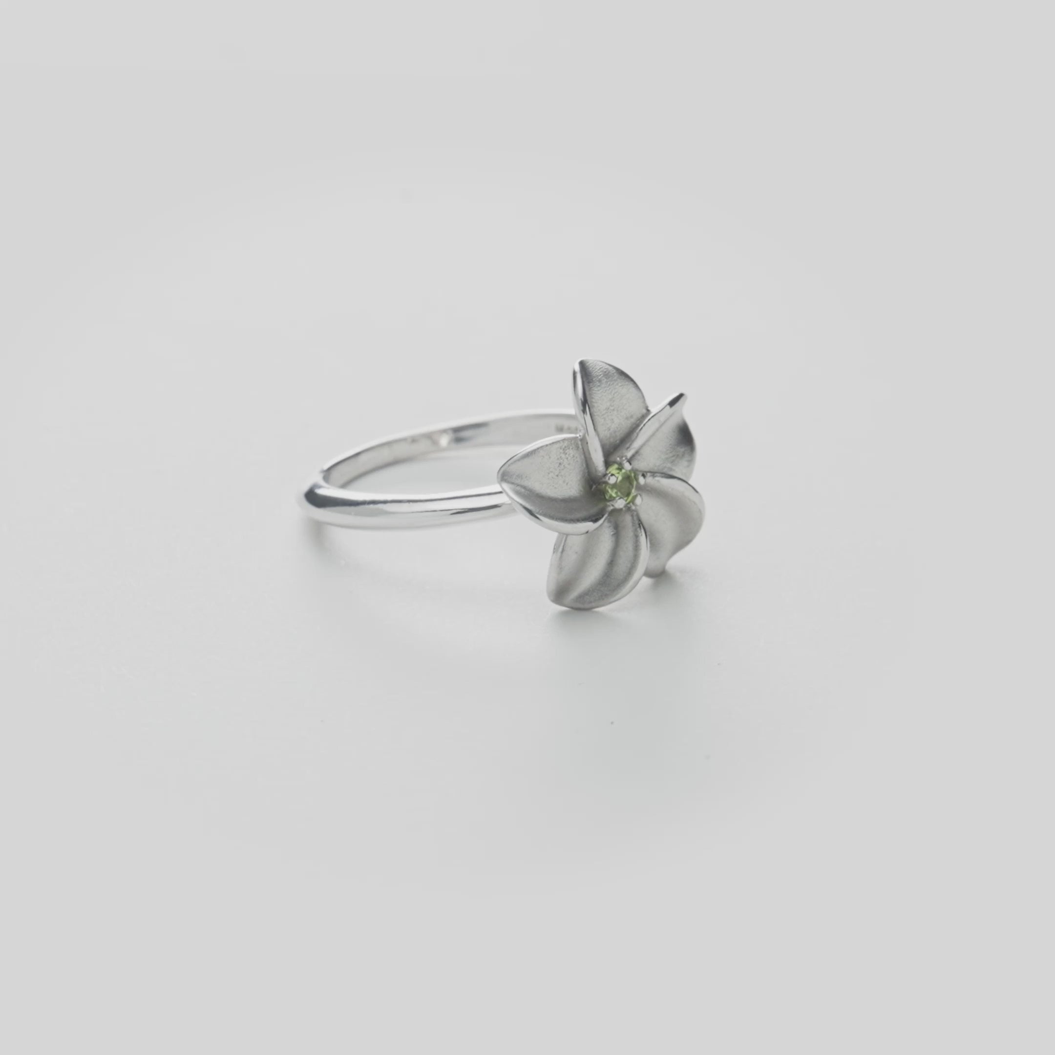 Plumeria Peridot Ring in Sterling Silver on a white turntable
