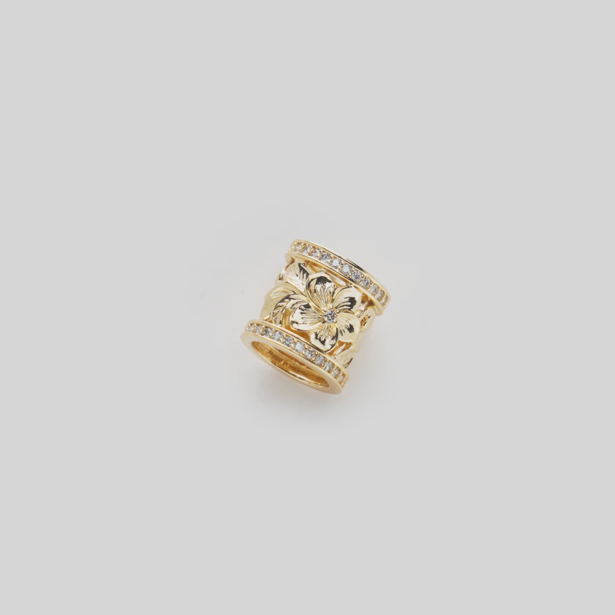 Vide of the 12mm Hawaiian Heirloom Plumeria Barrel Pendant in Gold with Diamonds turning on a white background