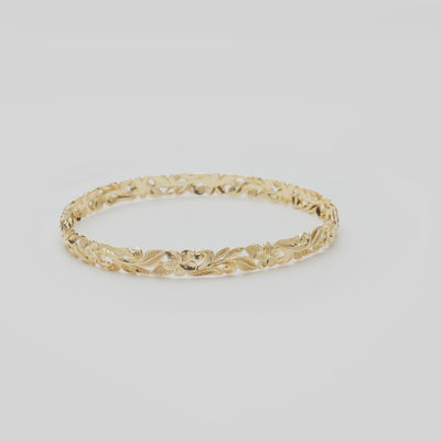 Hawaiian Heirloom Plumeria Bracelet in Gold on a white turntable