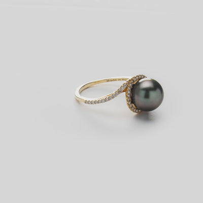 Video of a diamond halo, Tahitian black pearl ring in 14k yellow gold on a white background.