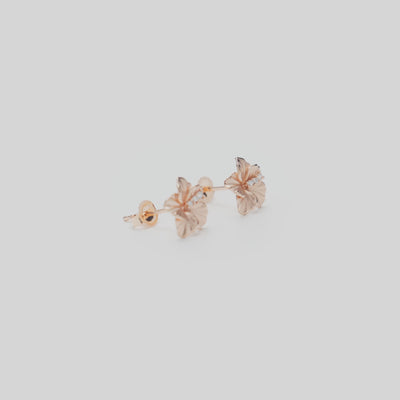 9.5mm Diamond Hibiscus Earrings in 14k Rose Gold on a white turntable