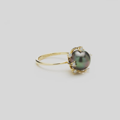 Close-up rotating video of a Tahitian black pearl ring with diamonds in 14k yellow gold against a white background