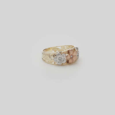 Hawaiian Heirloom Plumeria Ring in Tri Color Gold with Diamonds on a white turntable