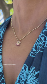 A video of a woman wearing a Ohia Lehua Ruby Pendant in Two Tone Gold - 15 mm - Maui Divers Jewelry
