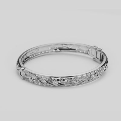 View of the Hawaiian Heirloom Plumeria Hinge Bracelet in Sterling Silver turning on a white background