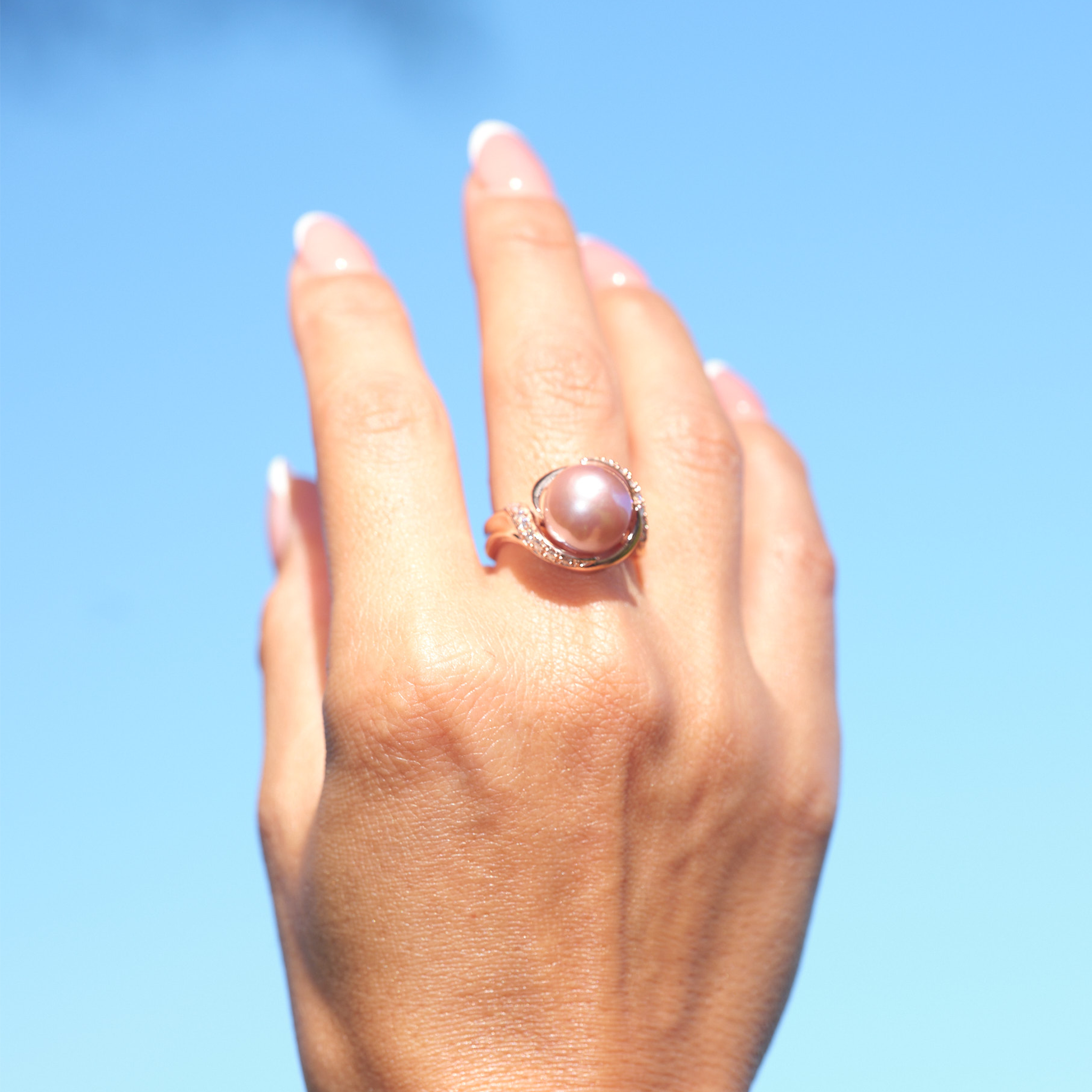 A woman's hand wearing a Lilac Freshwater Pearl Ring with Diamonds in Rose Gold (12-13mm)-Maui Divers Jewelry