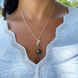 A woman wearing an Ocean Dance Jellyfish Tahitian Black Pearl Pendant in Gold with Diamonds - 9-10mm - Maui Divers Jewelry