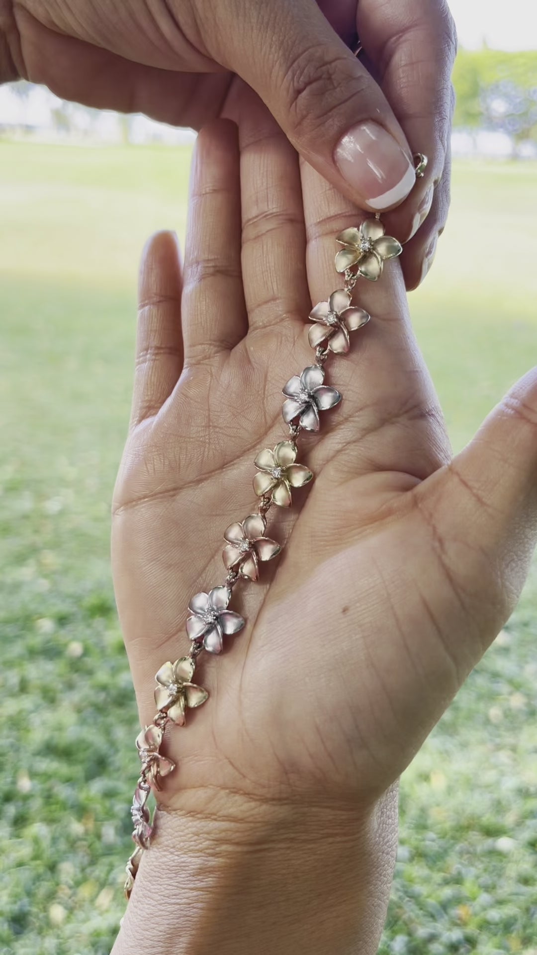 Video of a woman showing a Plumeria Bracelet in Tri Color Gold with Diamonds - 13mm - Maui Divers Jewelry