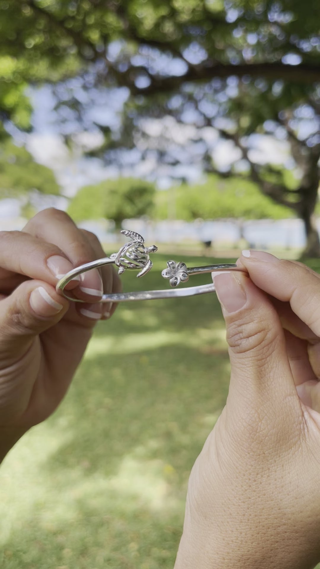 Video of a woman's hand wearing a Honu and Plumeria Bracelet and a Ring in Sterling Silver - Maui Divers Jewelry