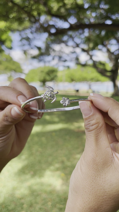 Video of a woman's hand wearing a Honu and Plumeria Bracelet and a Ring in Sterling Silver - Maui Divers Jewelry