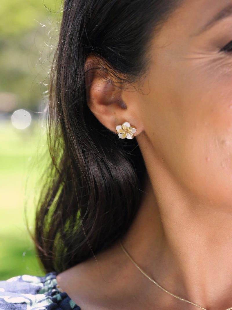 A woman's ear with Plumeria Mother of Pearl Earrings in Gold - 13mm - Maui Divers Jewelry