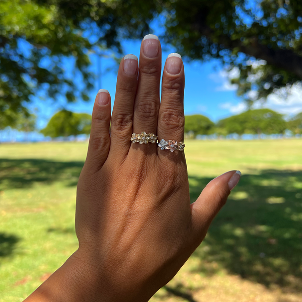 A woman's hand wearing a Plumeria Ring in Gold and with Diamond - 8mm - Maui Divers Jewelry