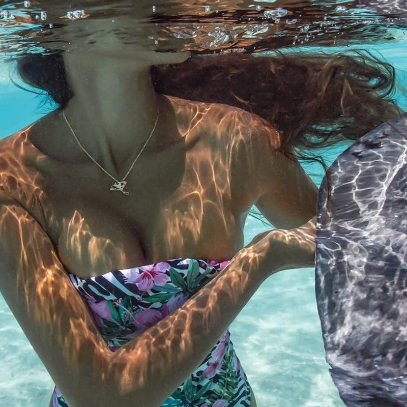 A woman's chest underwater wearing a Living Heirloom Manta Ray Pendant in Gold with Diamonds - 23mm-Maui Divers Jewelry