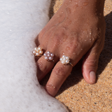 A woman's hand in the sand wearing three Tiny Bubbles White Freshwater Pearl Ring in Gold with Diamonds - Maui Divers Jewelry