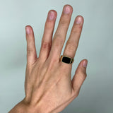 A man's hand with a Black Coral Ring in Gold - Maui Divers Jewelry