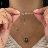A woman showing the backing of the 16-18" Adjustable Tahitian Black Floating Pearl Necklace in White Gold-Maui Divers Jewelry
