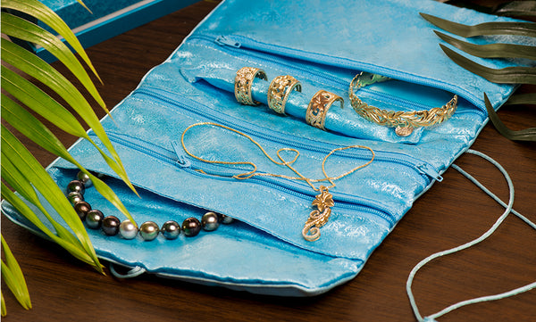 	A Maui Divers Jewelry Silk Travel Roll is sitting on a table.